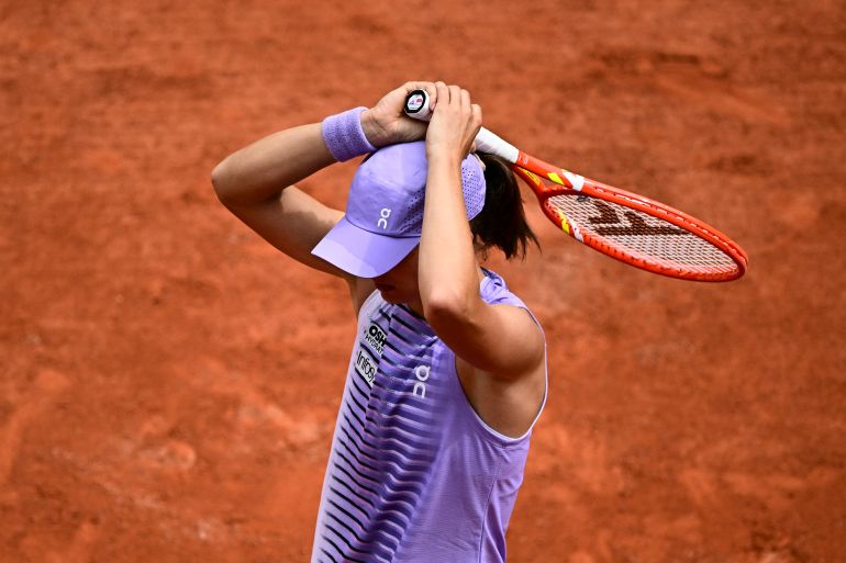 A polonesa Iga Swiatek reage ao jogar contra a ucraniana Marta Kostyuk durante a partida individual feminina no 8º dia do torneio de tênis do Aberto da França, na quadra Philippe-Chatrier, no Complexo Roland-Garros, em Paris, em 31 de maio de 2026. (Foto de JULIEN DE ROSA / AFP)
