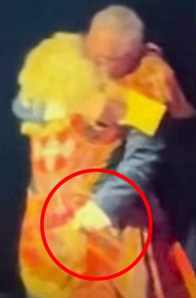 O chefe do 2HD, Guy Ashford, é fotografado agarrando a vencedora do prêmio Cheralyn Darcey pelas costas durante um abraço no palco no Australian Audio Awards